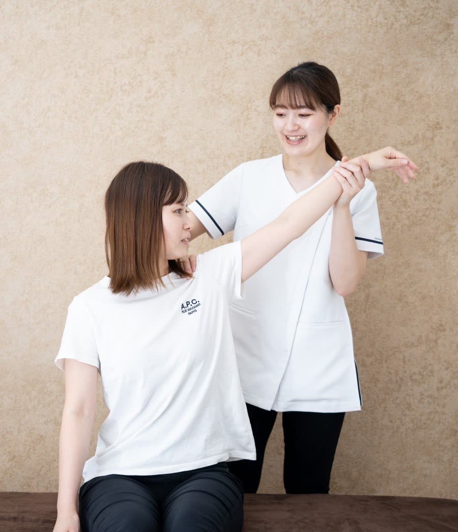 女性スタッフが肩の動きをチェックしている様子